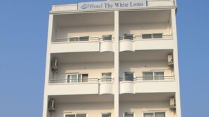 A multi-story hotel building with balconies and air conditioning units. - The White Lake Hotel (Tansen)