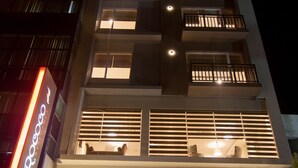 A multi-story hotel with a modern design, featuring balconies on each floor, a parking area, and a visible sign for the hotel. - Rococo Residence (Colombo)