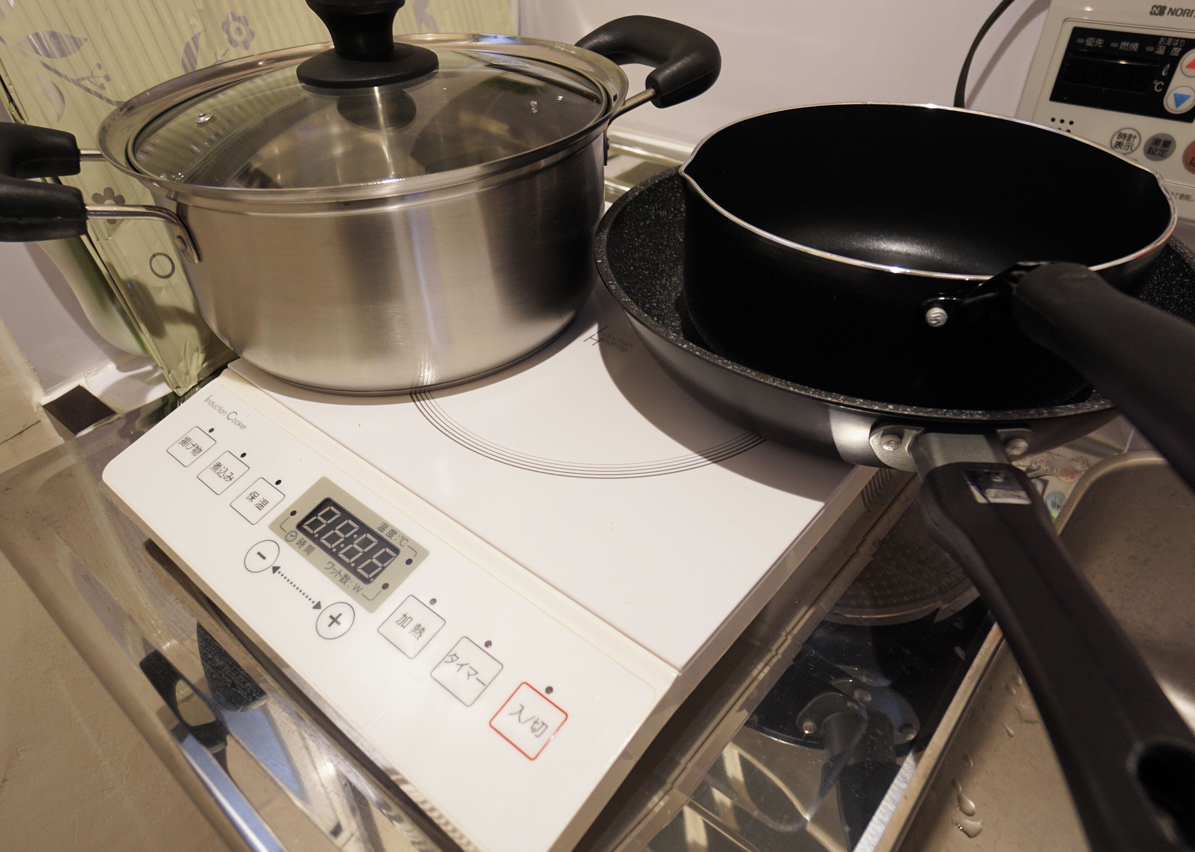 Una cocina con estufa, una olla y una sartén.