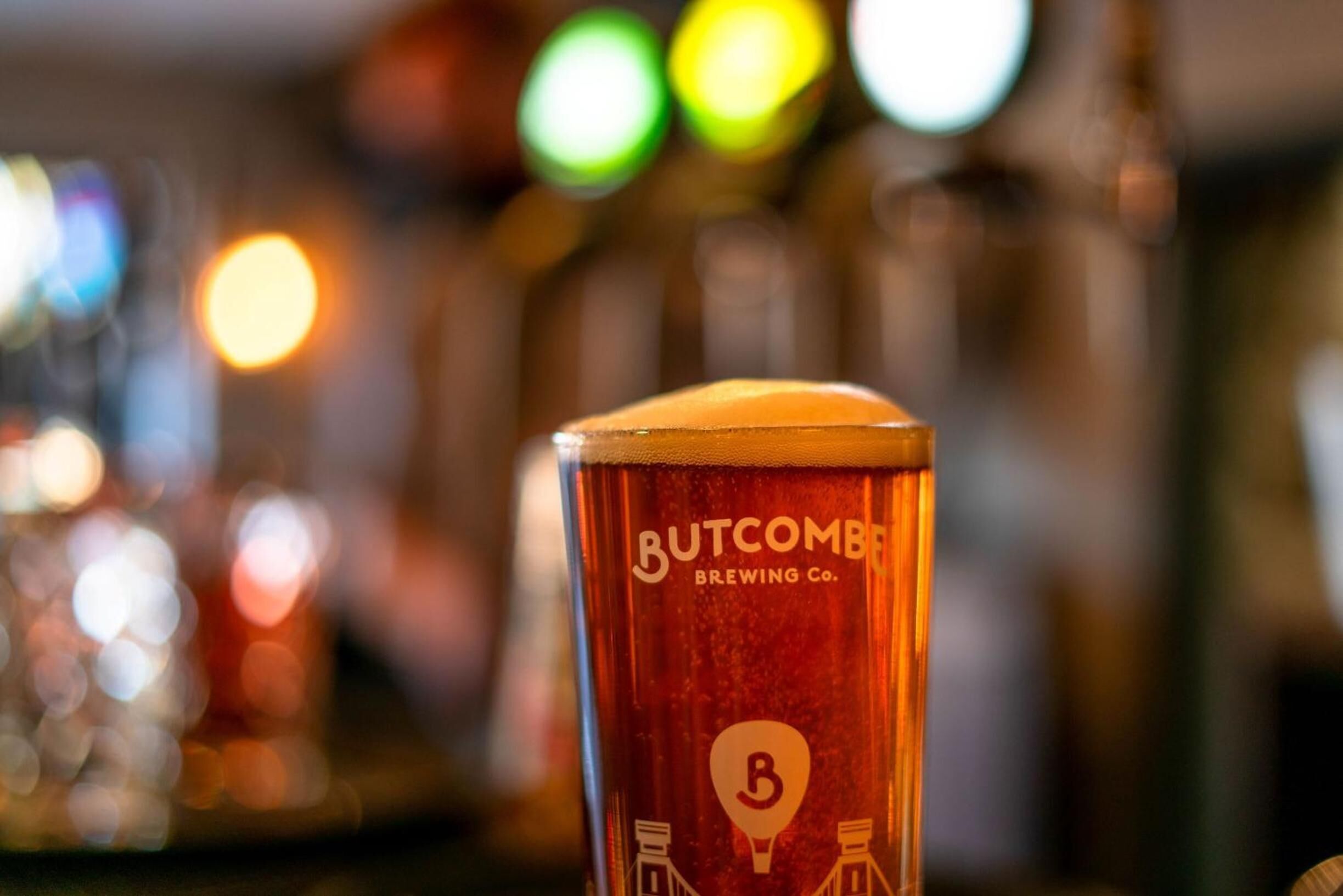 Ein Glas Bier mit dem Logo der Butcombe Brewing Co.