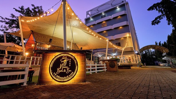 A building with a sign that reads "Marche Bistro & Bar" and a canopy with string lights. - Nora Bukit Hotel (Phuket)