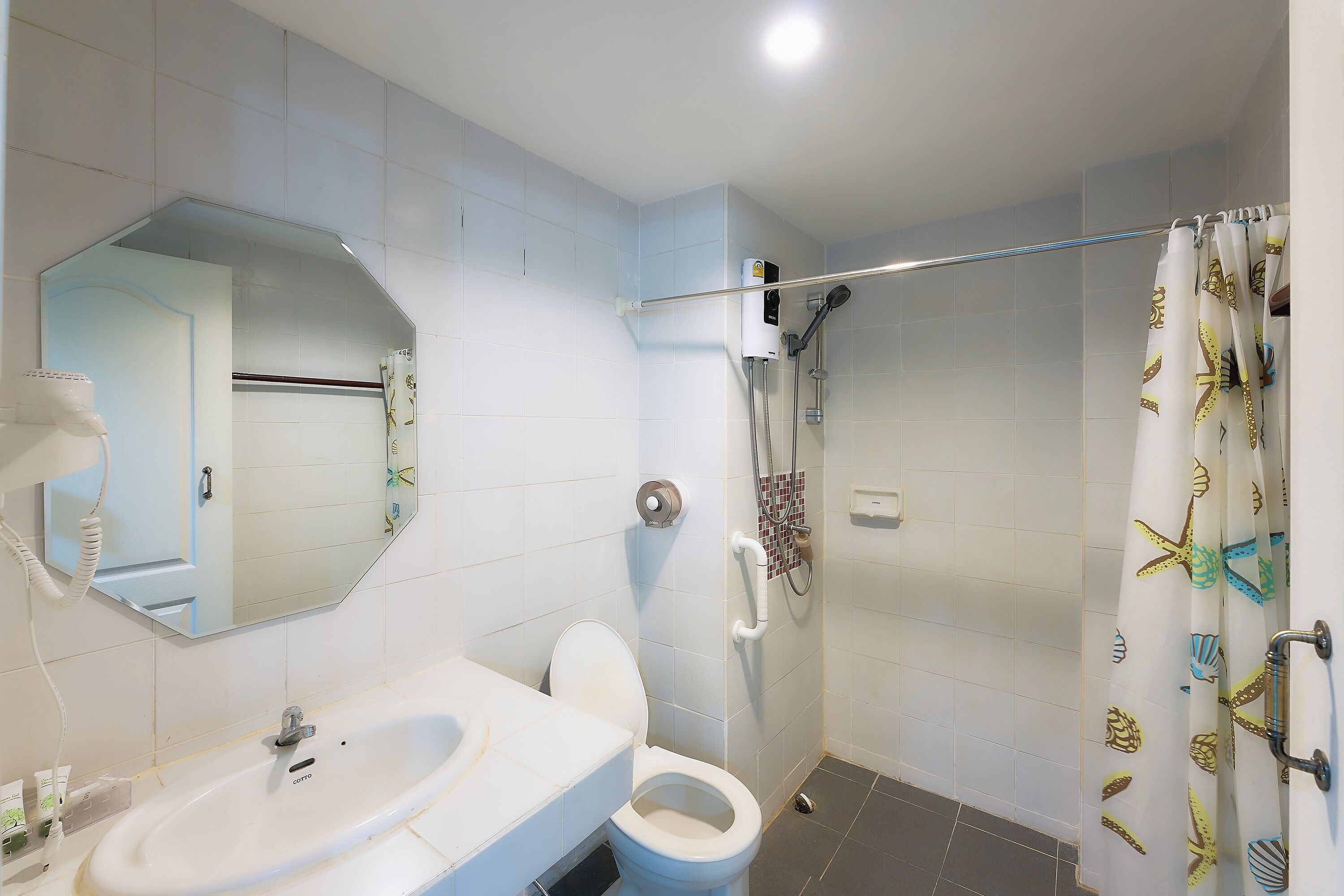 A bathroom with a sink, toilet, and shower.
