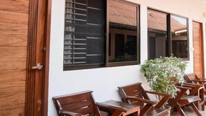A building with wooden doors, large windows, and a clock on the wall. - Orchid House (Chiang Rai)