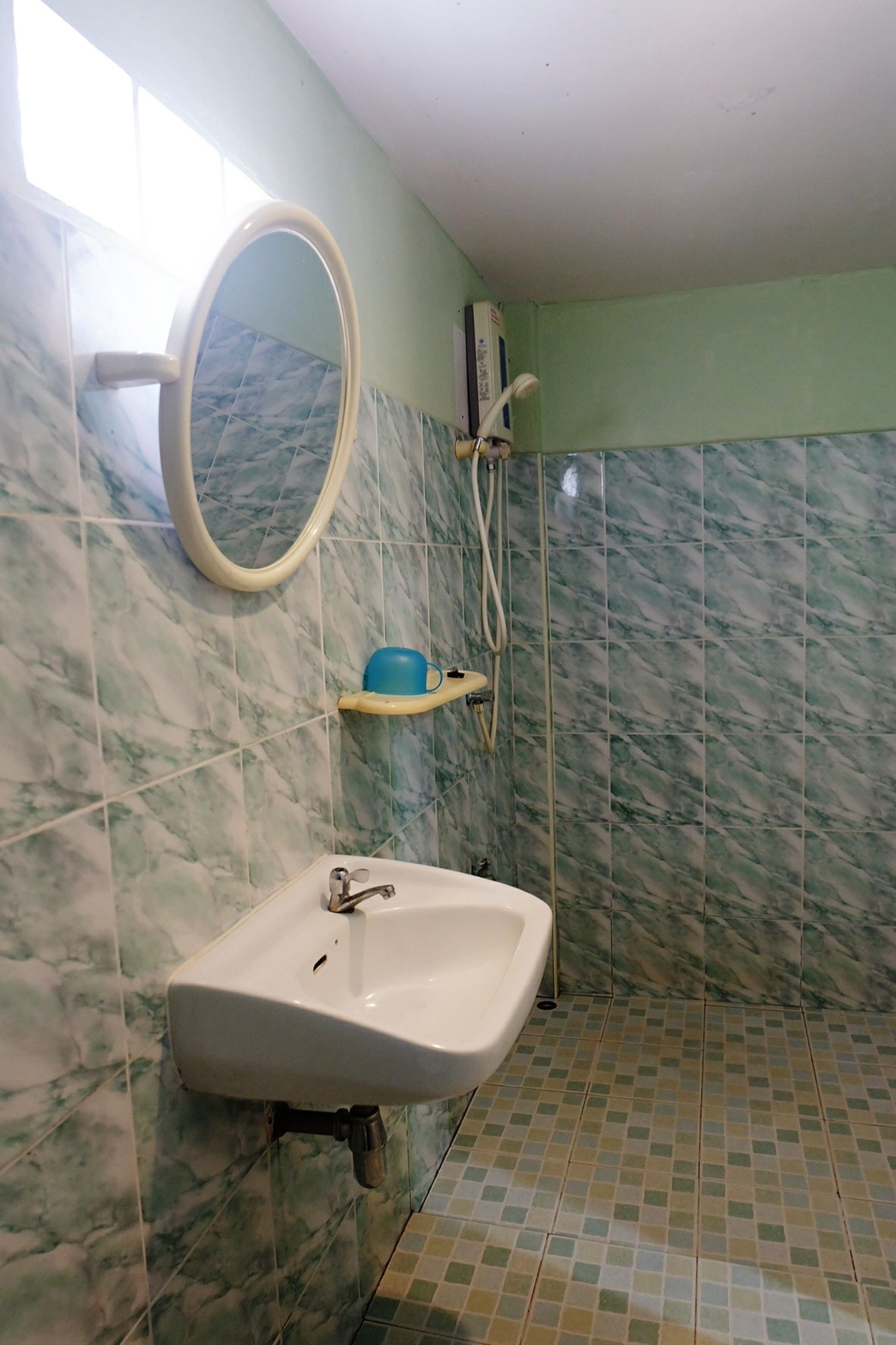 Un baño con lavamanos, espejo y ducha.