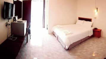 A hotel room with a bed, a desk, a television, and a nightstand.