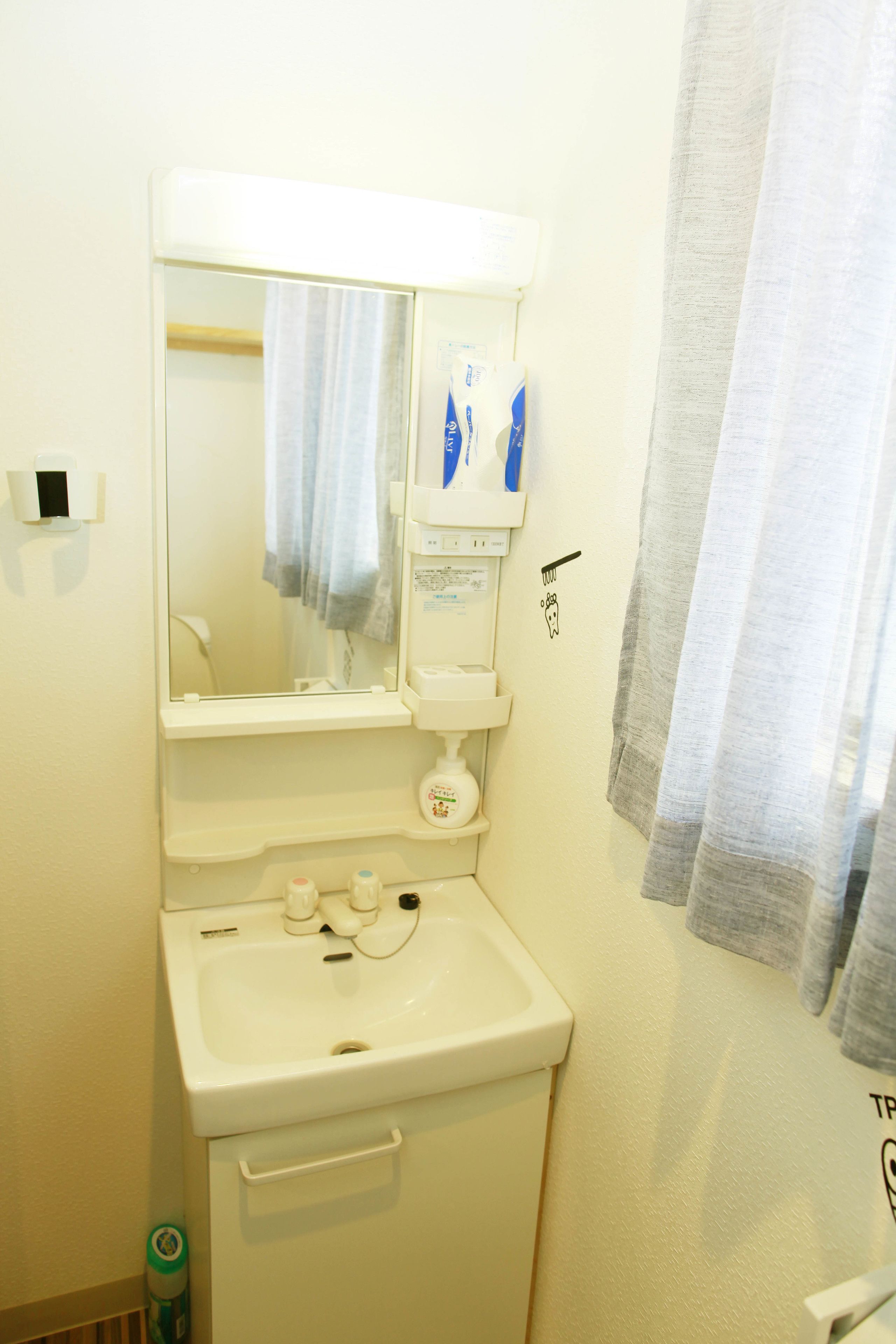 A bathroom with a sink, mirror, towel rack, and a shower curtain.