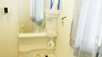 A bathroom with a sink, mirror, towel rack, and a shower curtain.
