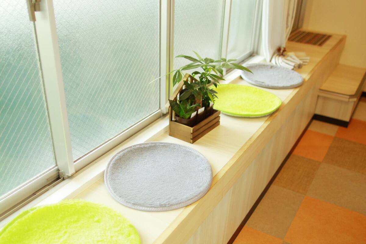 A row of windows with frosted glass, a checkered floor, and a small plant on the windowsill.