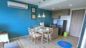 A compact kitchen with wooden cabinets, a built-in stove, and a refrigerator. - Rain Cha-am Hua-hin by Noppawan (Cha-am)