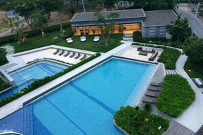 Una piscina al aire libre, sillones reclinables de piscina