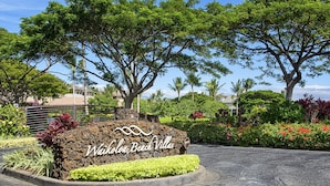 A sign for Waikoloa Beach Villas with a landscaped garden and trees. - Waikoloa Beach S H32 2 Bedroom Condo by RedAwning (Waikoloa)