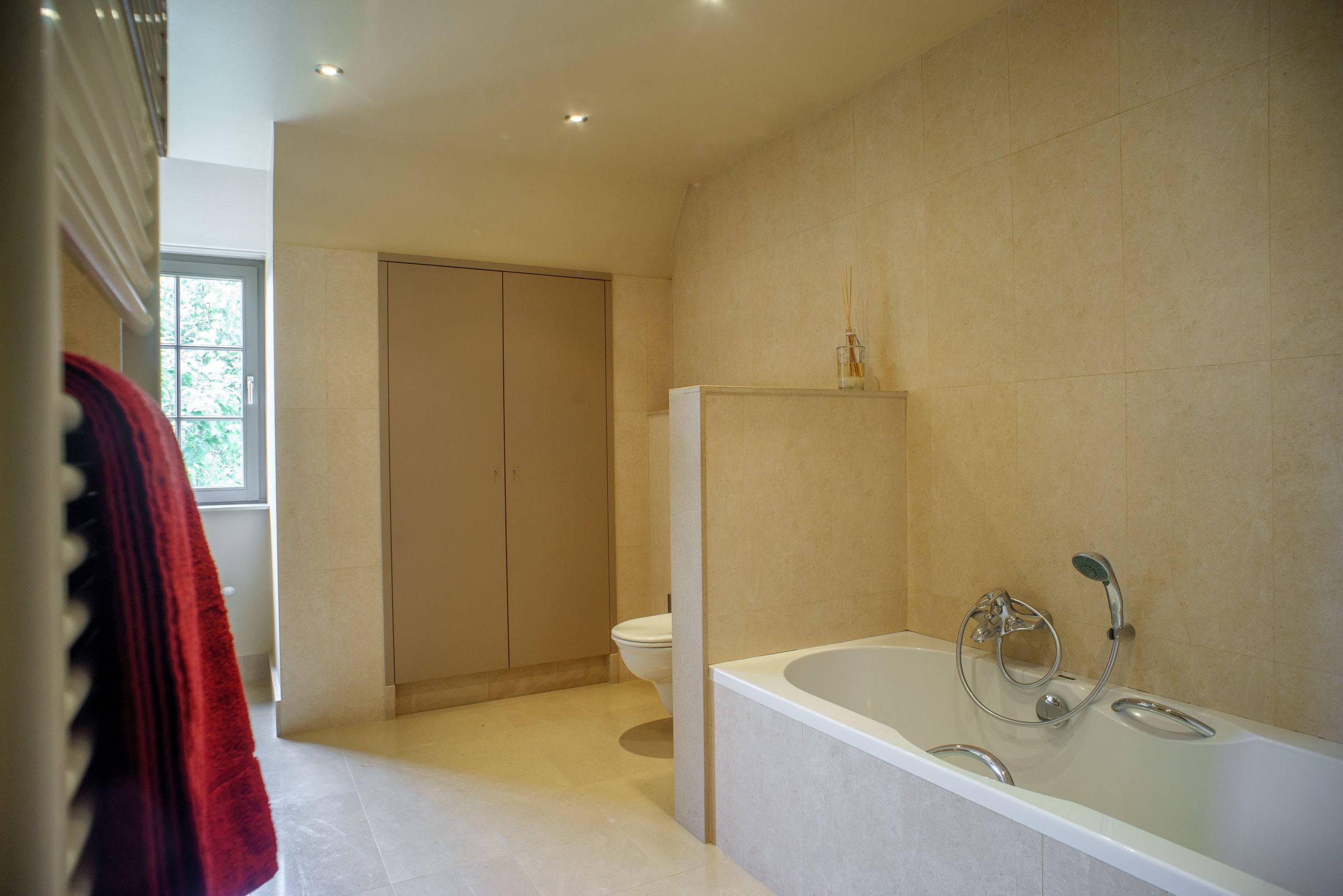 Un baño moderno con bañera, inodoro y vestidor.