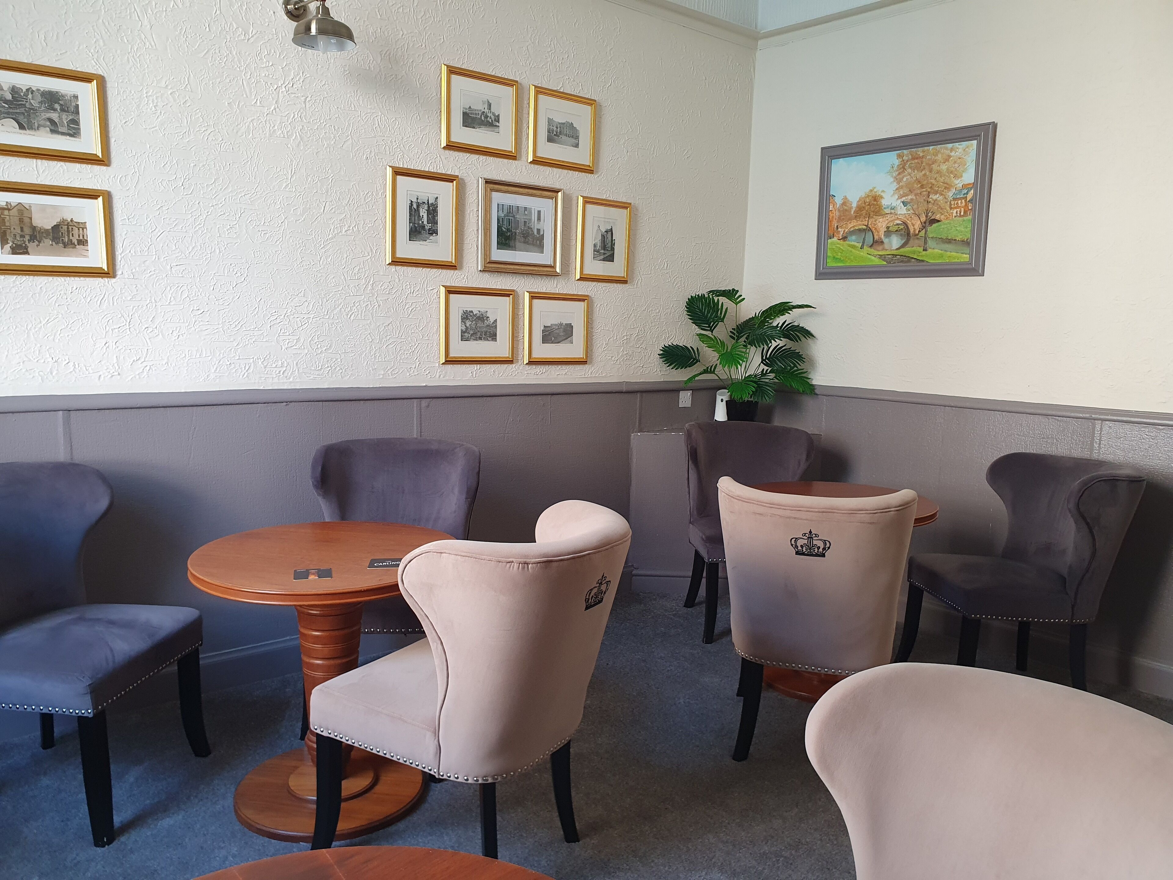 A room with a round wooden table and six chairs, some with decorative elements.