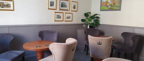 A room with a round wooden table and six chairs, some with decorative elements.