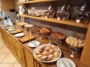 A buffet with various pastries and desserts, including croissants, cakes, and a variety of other baked goods. - Hotel Rododendro Val di Fassa (Campitello di Fassa)