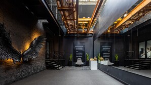 Un intérieur moderne avec un mur en briques, une grande sculpture en métal et un escalier.