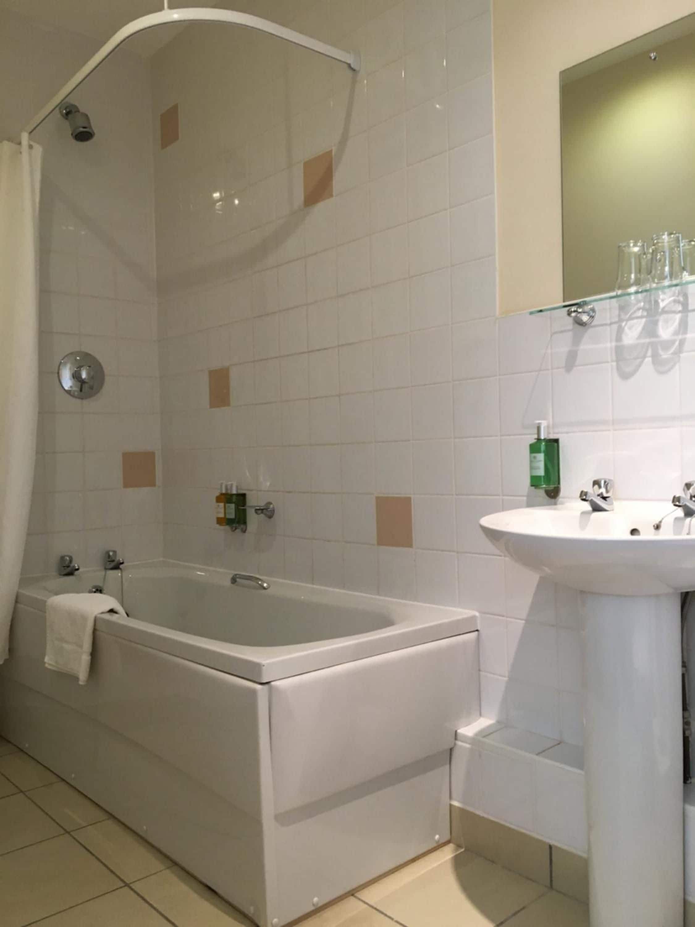 Une salle de bain avec une baignoire, un lavabo et une douche.