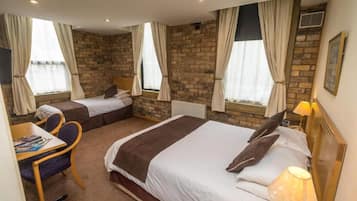 Habitación de hotel con dos camas, un escritorio y una silla.