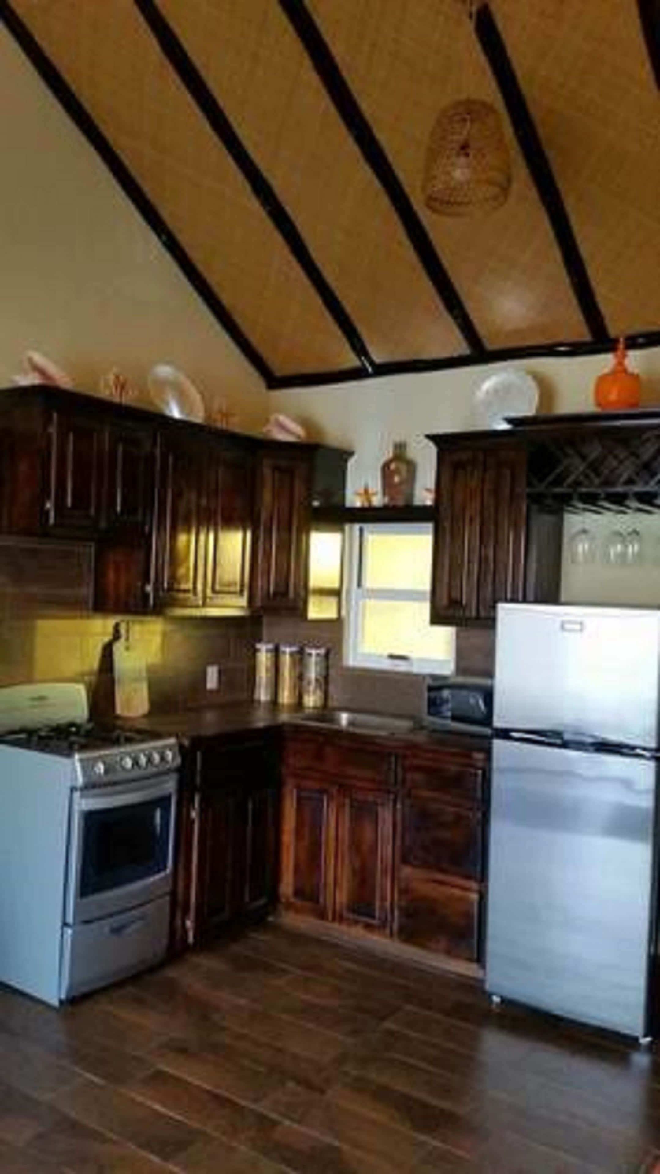 A kitchen with wooden cabinets, a stove, and a refrigerator.
