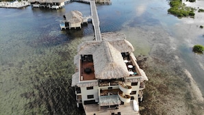 An overwater bungalow with a pool, thatched-roof structures, and a wooden deck. - Lina Point Belize Overwater Resort (San Pedro)