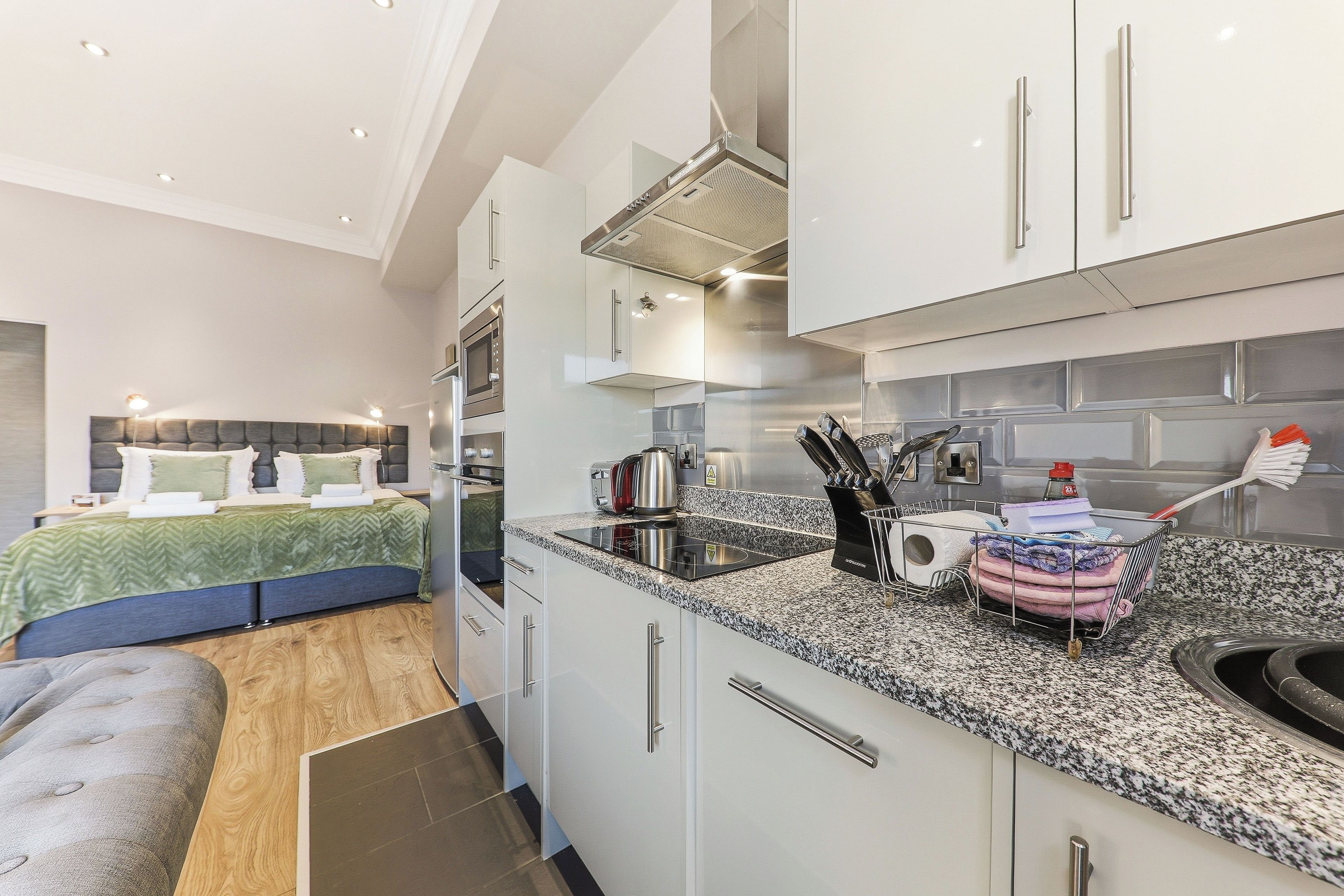 A compact kitchen with modern appliances, a built-in oven, and a coffee maker.
