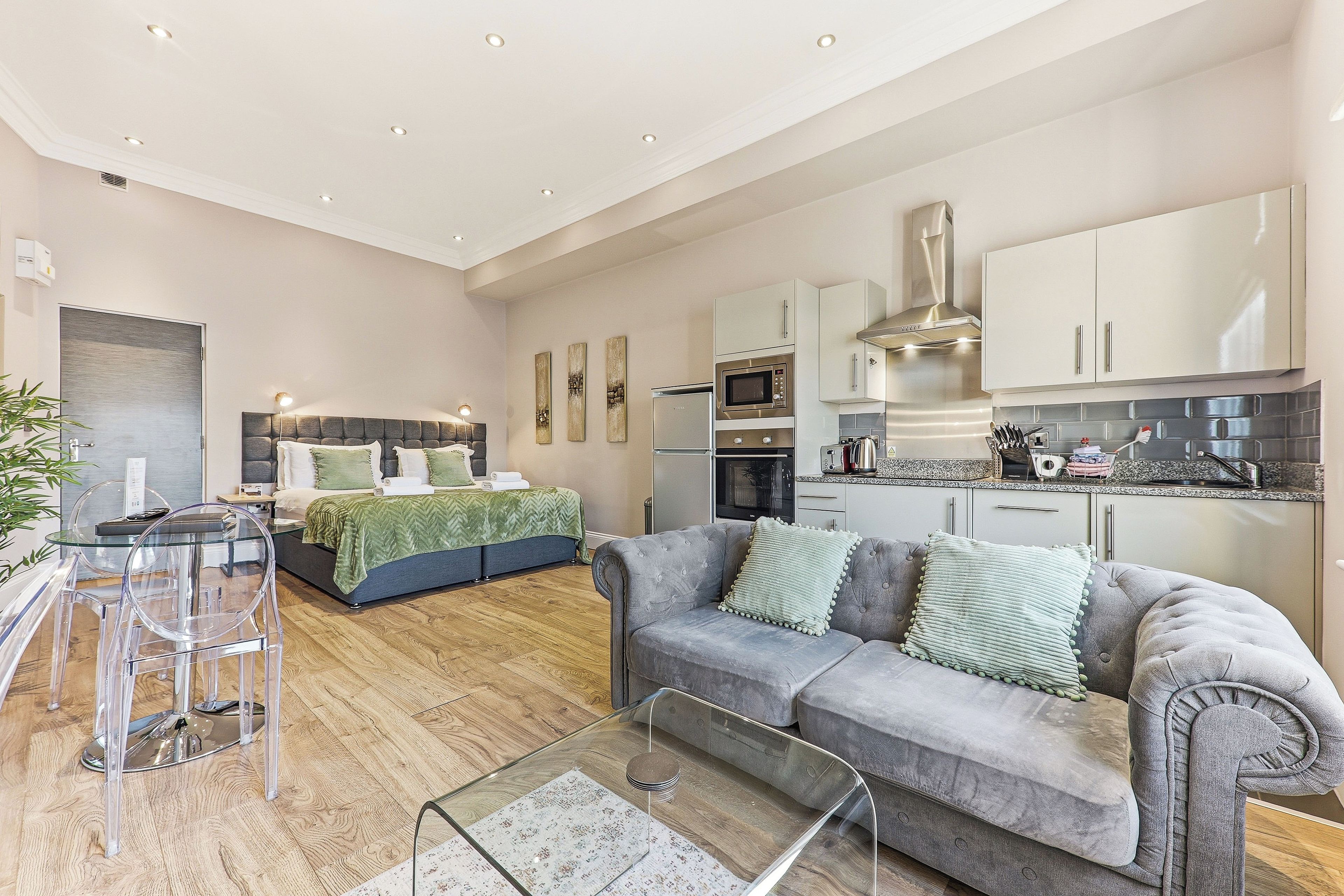 A modern apartment with a living area, a bedroom, and a kitchen.