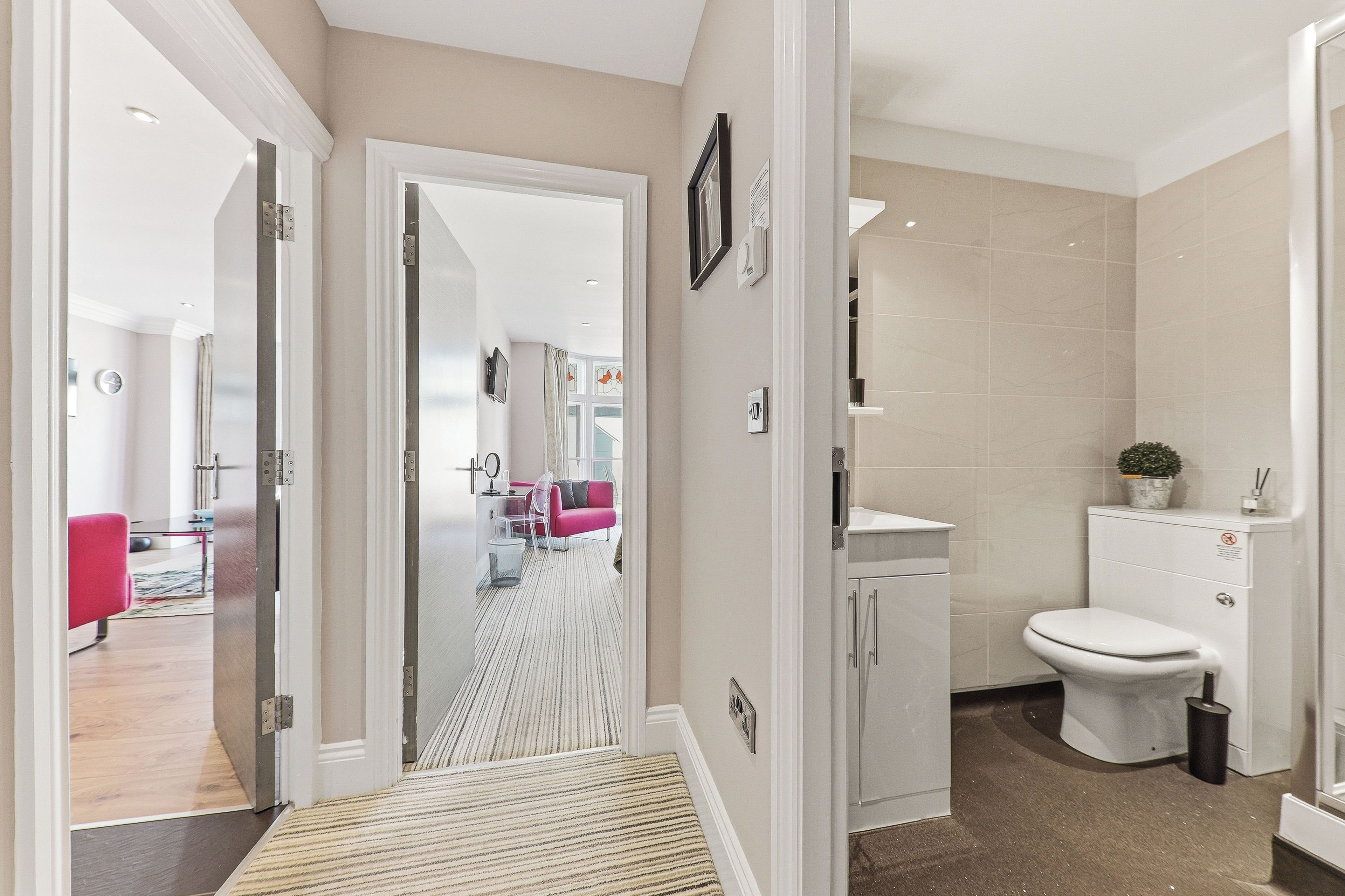A modern bathroom with a toilet, sink, and shower.