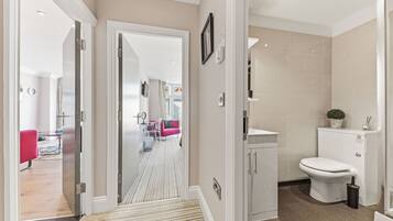 A modern bathroom with a toilet, sink, and shower.