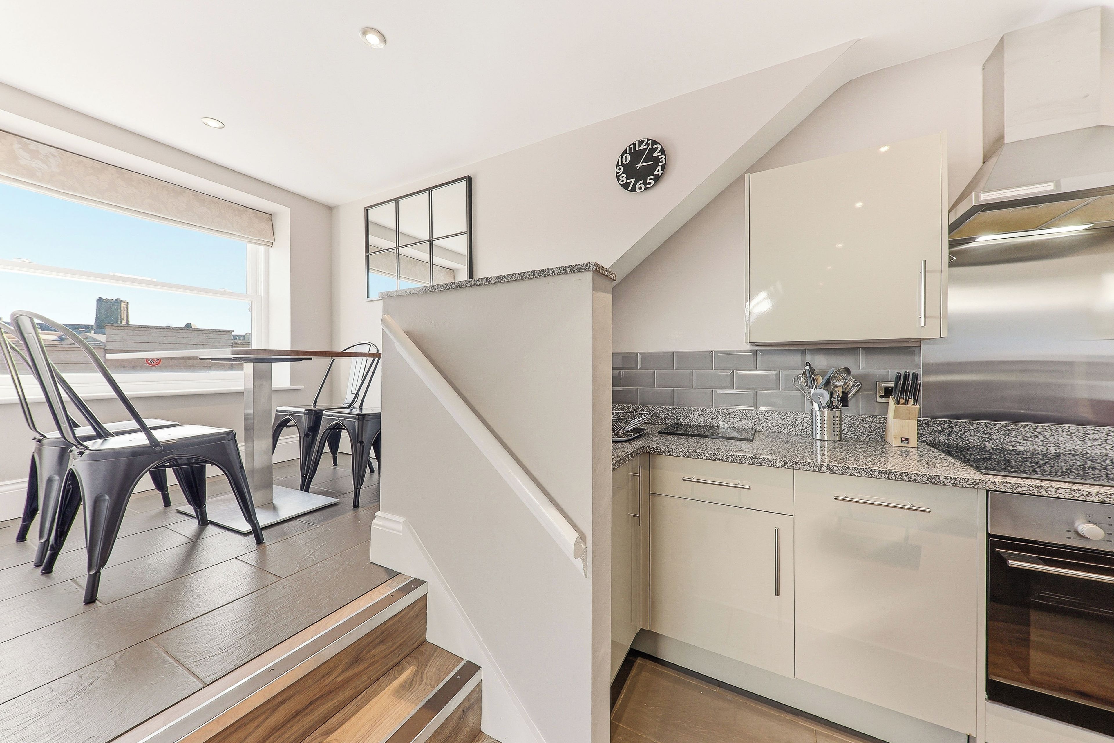 A modern kitchen with a built-in oven, stainless steel appliances, and a granite countertop.