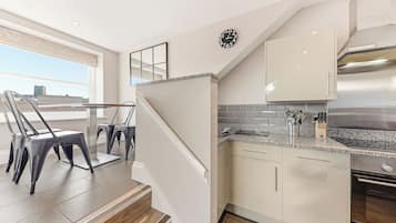 A modern kitchen with a built-in oven, stainless steel appliances, and a granite countertop.