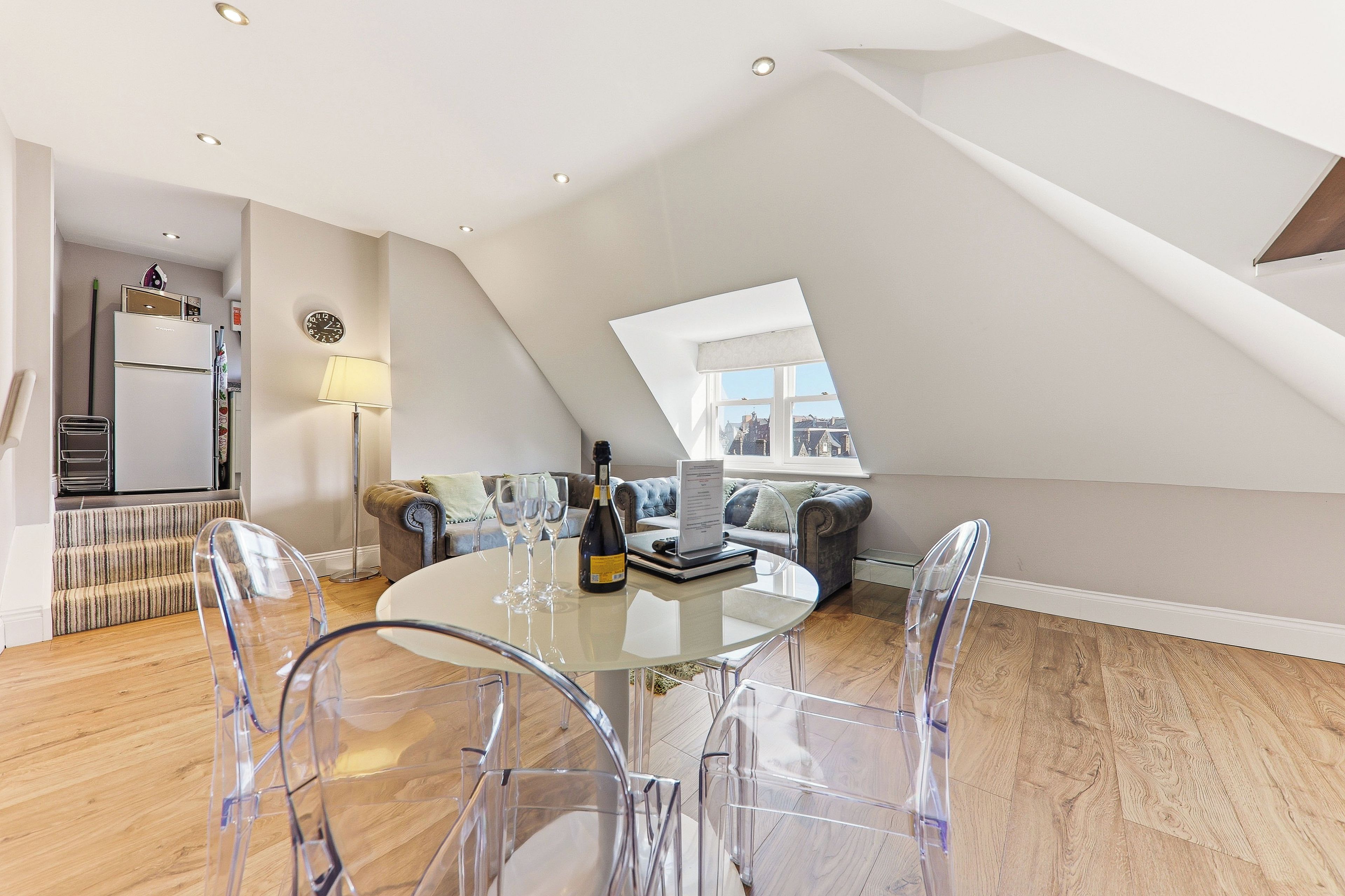 Ein modernes Loft-Apartment mit Essbereich, einer Couch und Blick auf die Stadt.