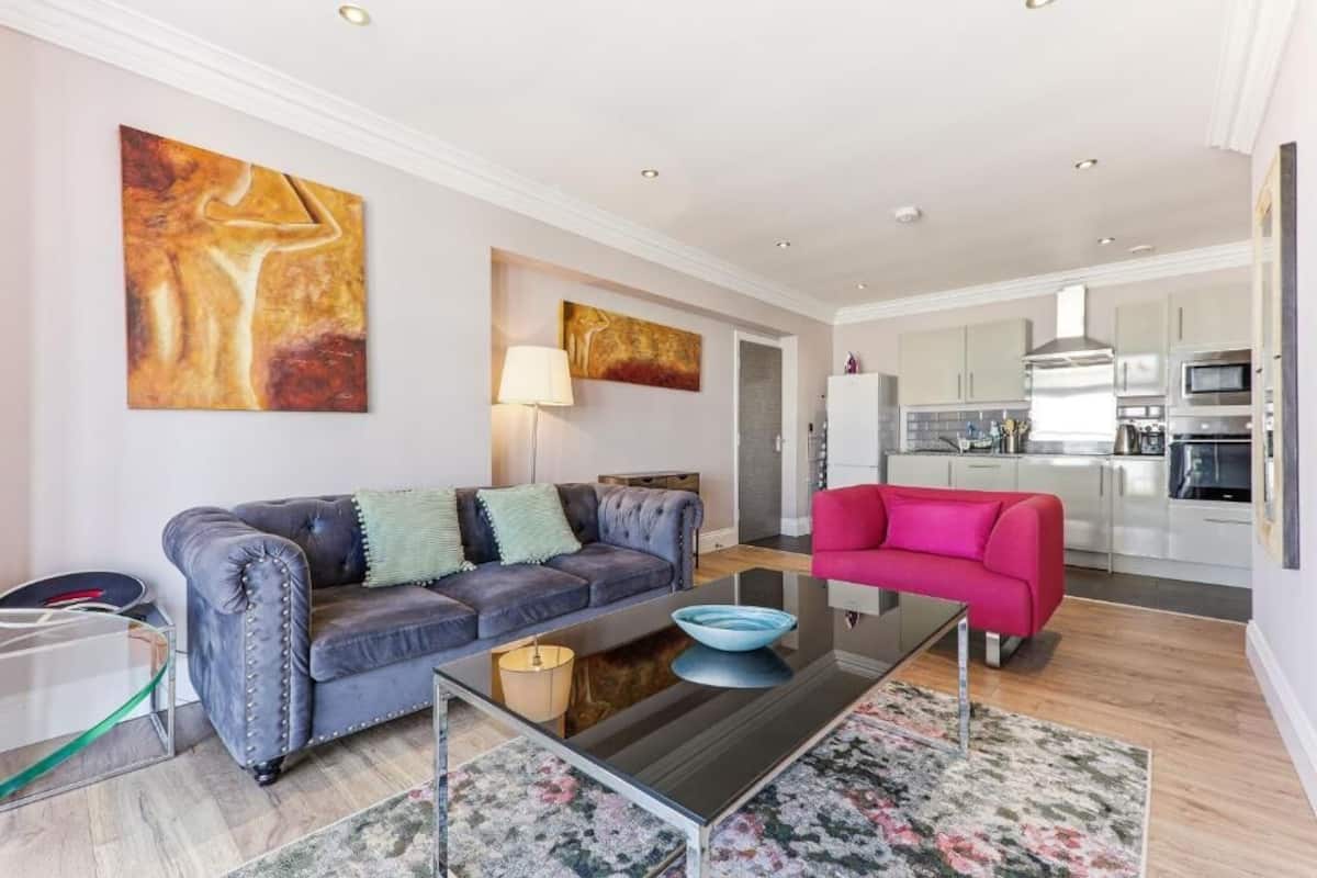 A modern living room with a sofa, a coffee table, and artwork on the walls.