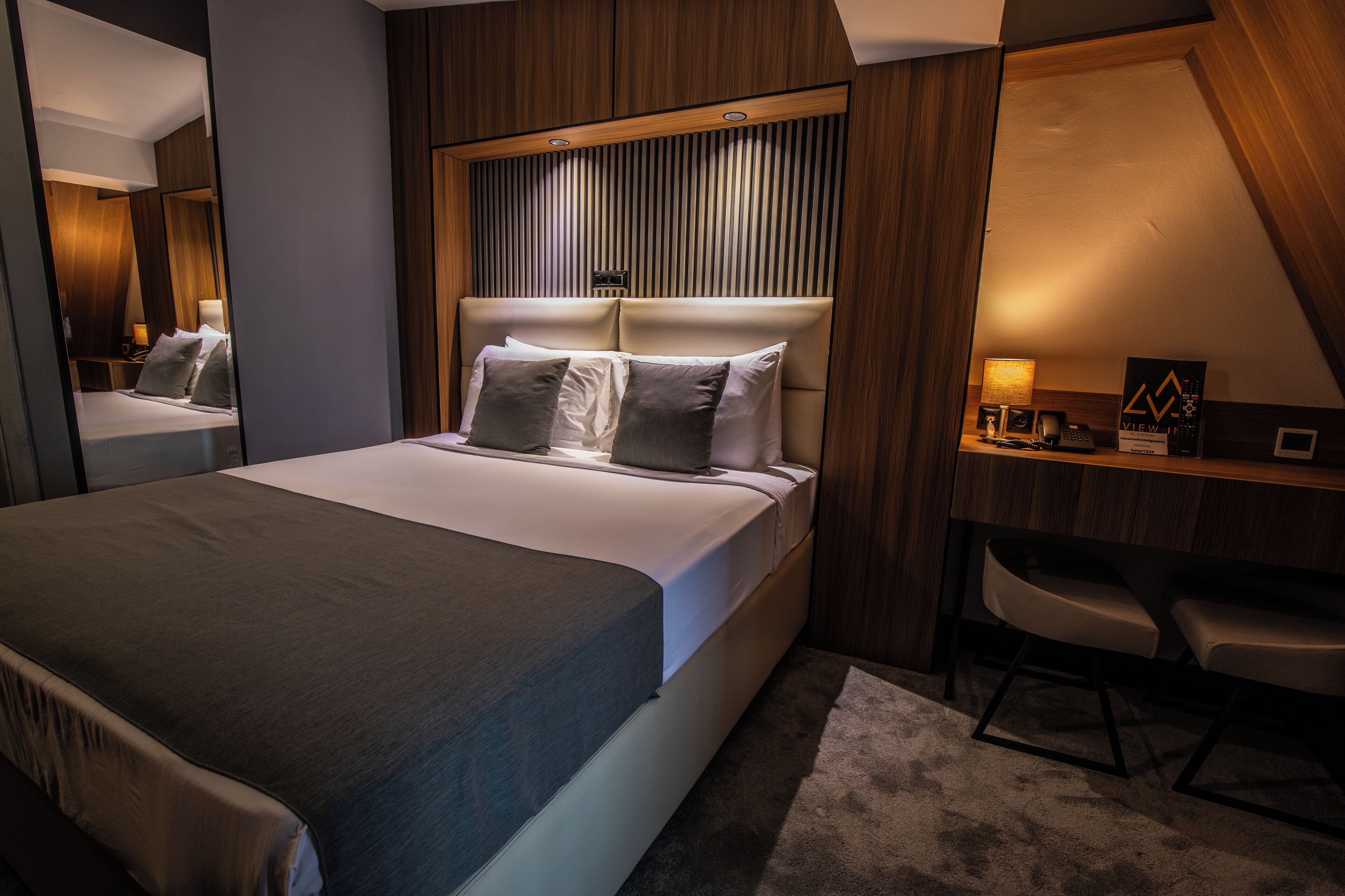 Una habitación de hotel moderna con una cama grande, un escritorio y una silla.