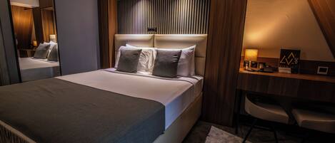 Una habitación de hotel moderna con una cama grande, un escritorio y una silla.