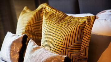 A close-up of a bed with patterned pillows and a textured blanket.