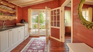 Een houten interieur met een keuken, een eethoek en een grote spiegel.