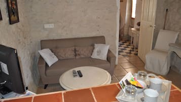 A living room with a sofa, a coffee table, and a tray with cups and a remote control.