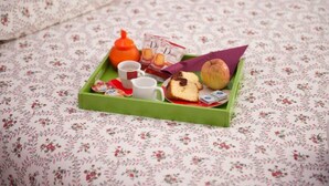 A tray with food items and a teapot on a floral-patterned tablecloth. - B&B Da Ninetta (Rome)