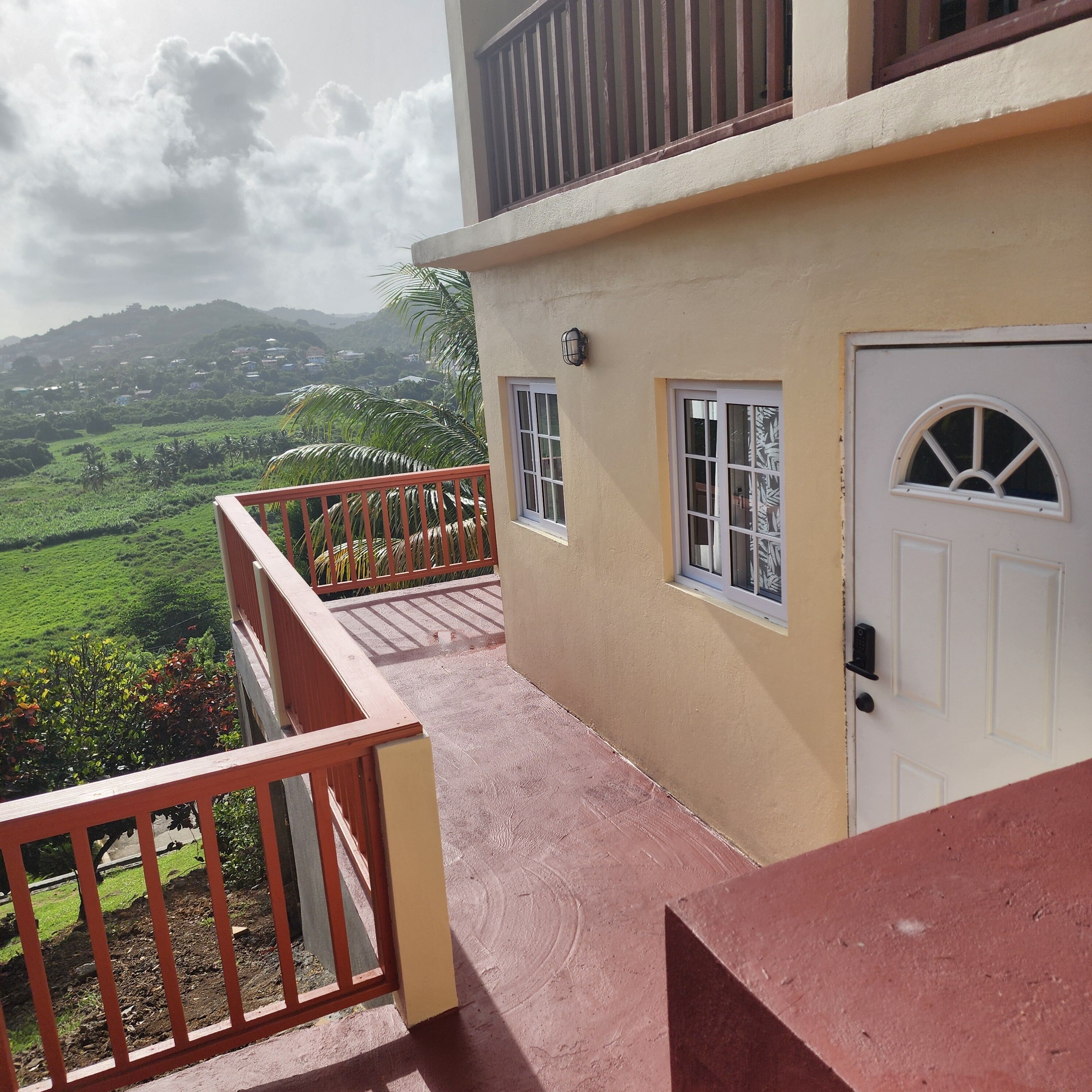 Un bâtiment doté d’un balcon donnant sur un paysage verdoyant.