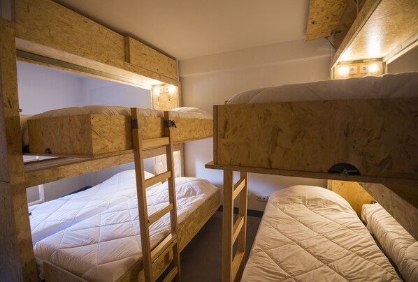 Habitación con literas, paredes de madera y una distribución sencilla.