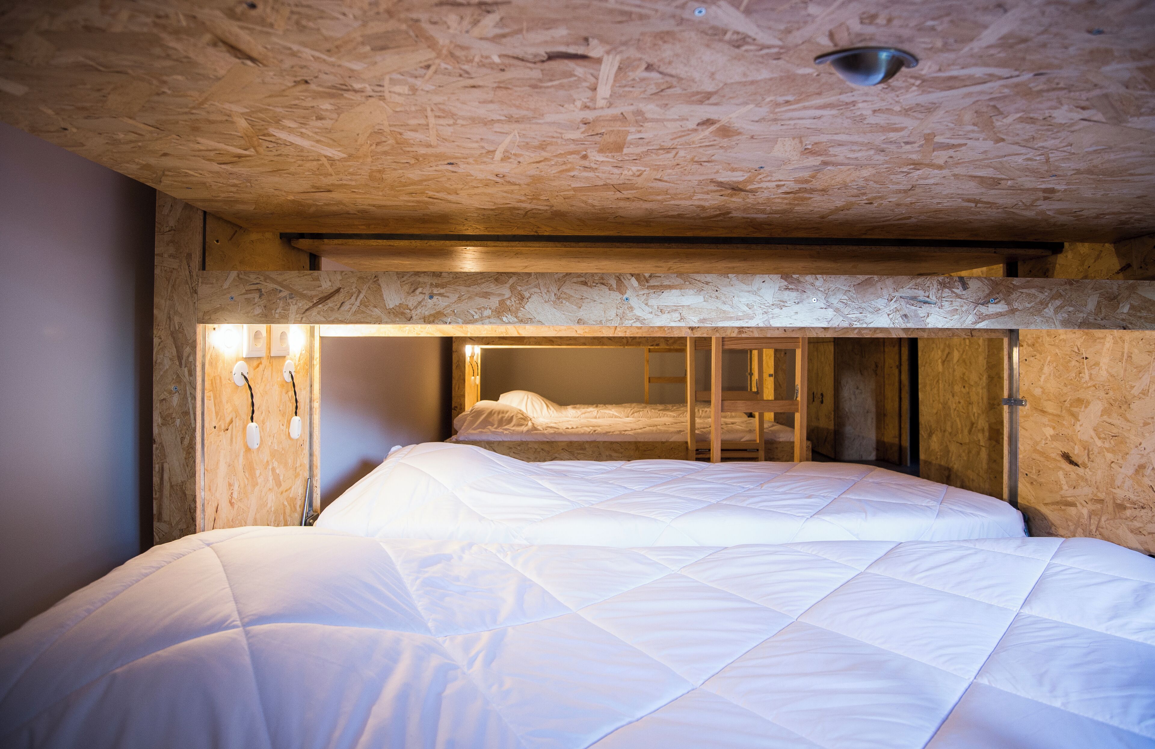 Een kamer met een stapelbed, houten plafond en zichtbare balken.