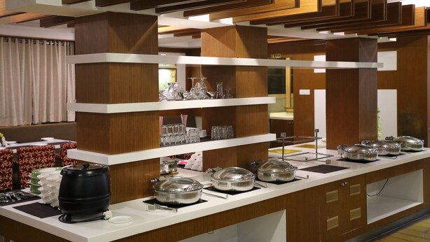 Un buffet avec plusieurs points de service, comprenant de la vaisselle et des récipients pour les aliments.