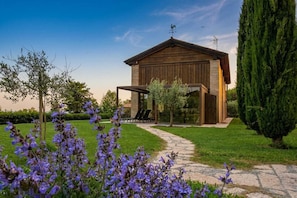 A rustic wooden building with a stone pathway leading to a covered outdoor seating area.