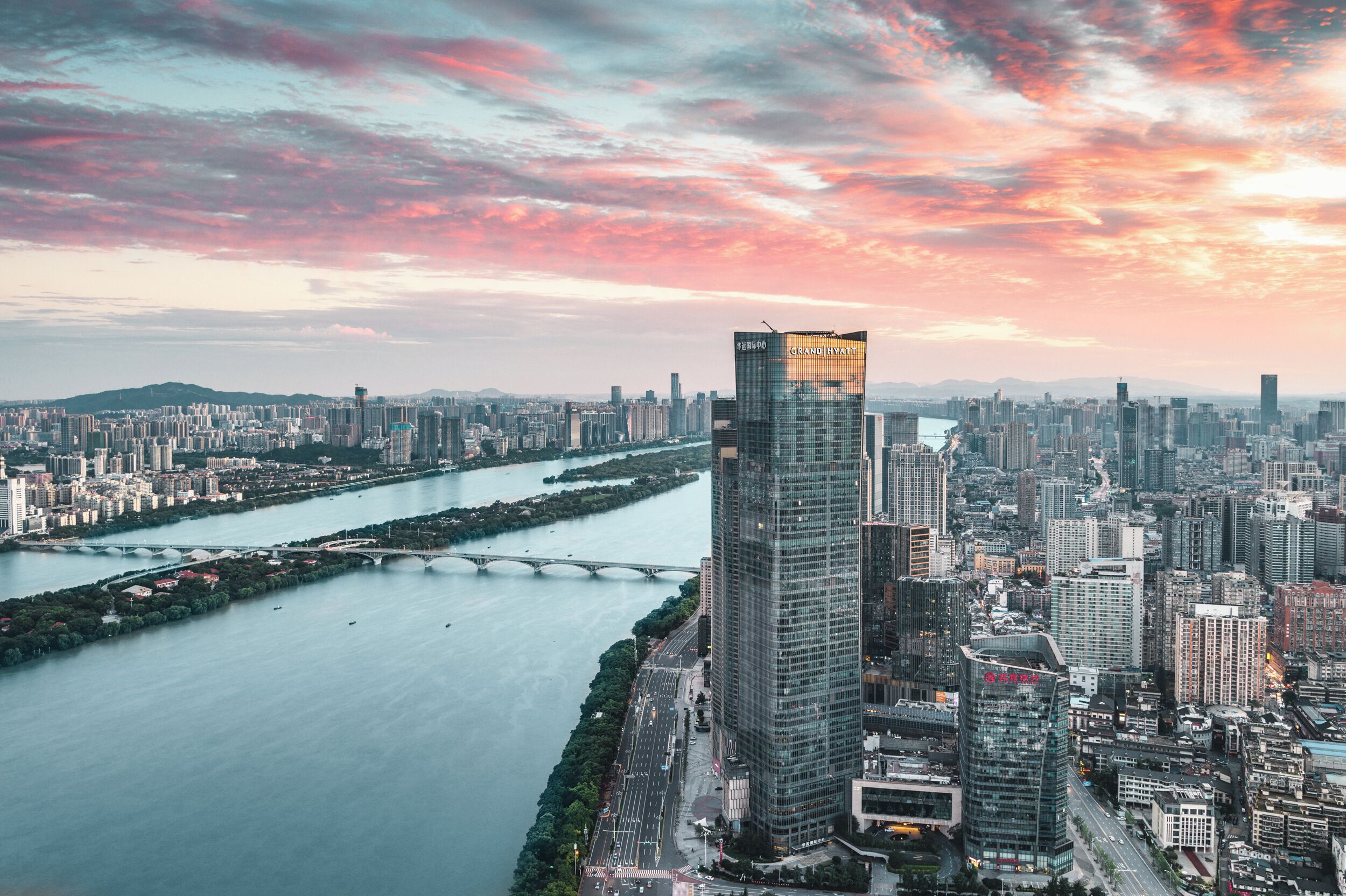 A cityscape with a prominent skyscraper, a river, and a bridge.