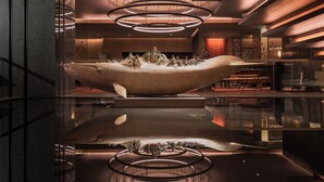 A modern interior with a large whale sculpture centerpiece, reflective flooring, and contemporary lighting fixtures. - Grand Hyatt Changsha (Changsha)