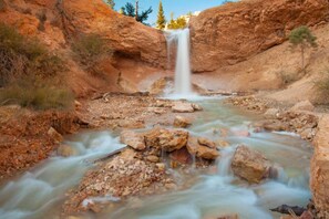 A waterfall in a rocky canyon with clear water flowing over rocks.