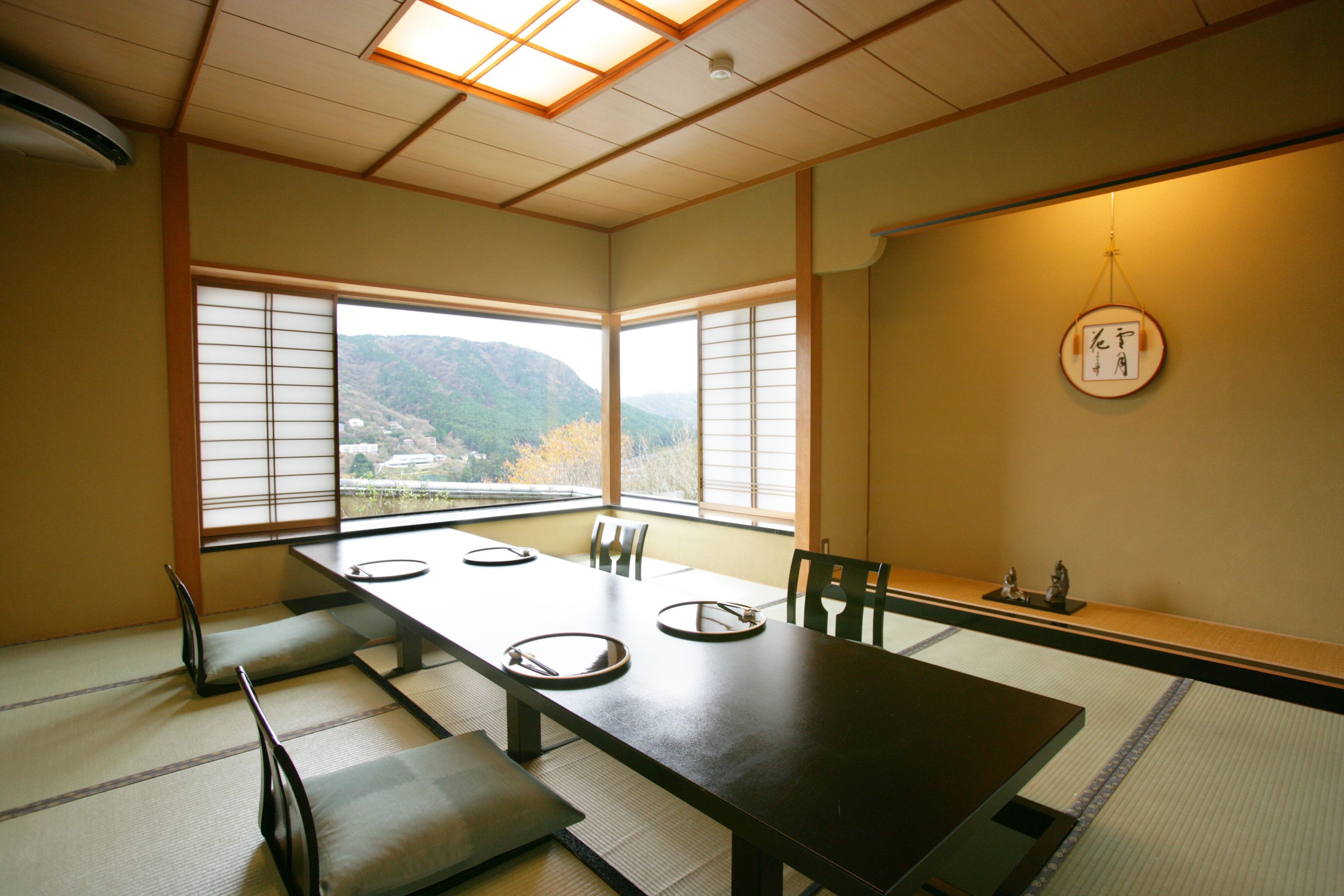 A traditional Japanese-style room with tatami flooring, a low table, and sliding shoji screens.