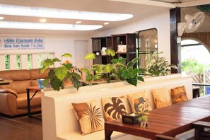 A modern interior with a sofa, wooden table, and potted plants. - P.a.n. Beach Bungalow (Krabi)
