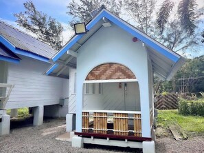 A house with a white exterior, a blue roof, and a wooden door.