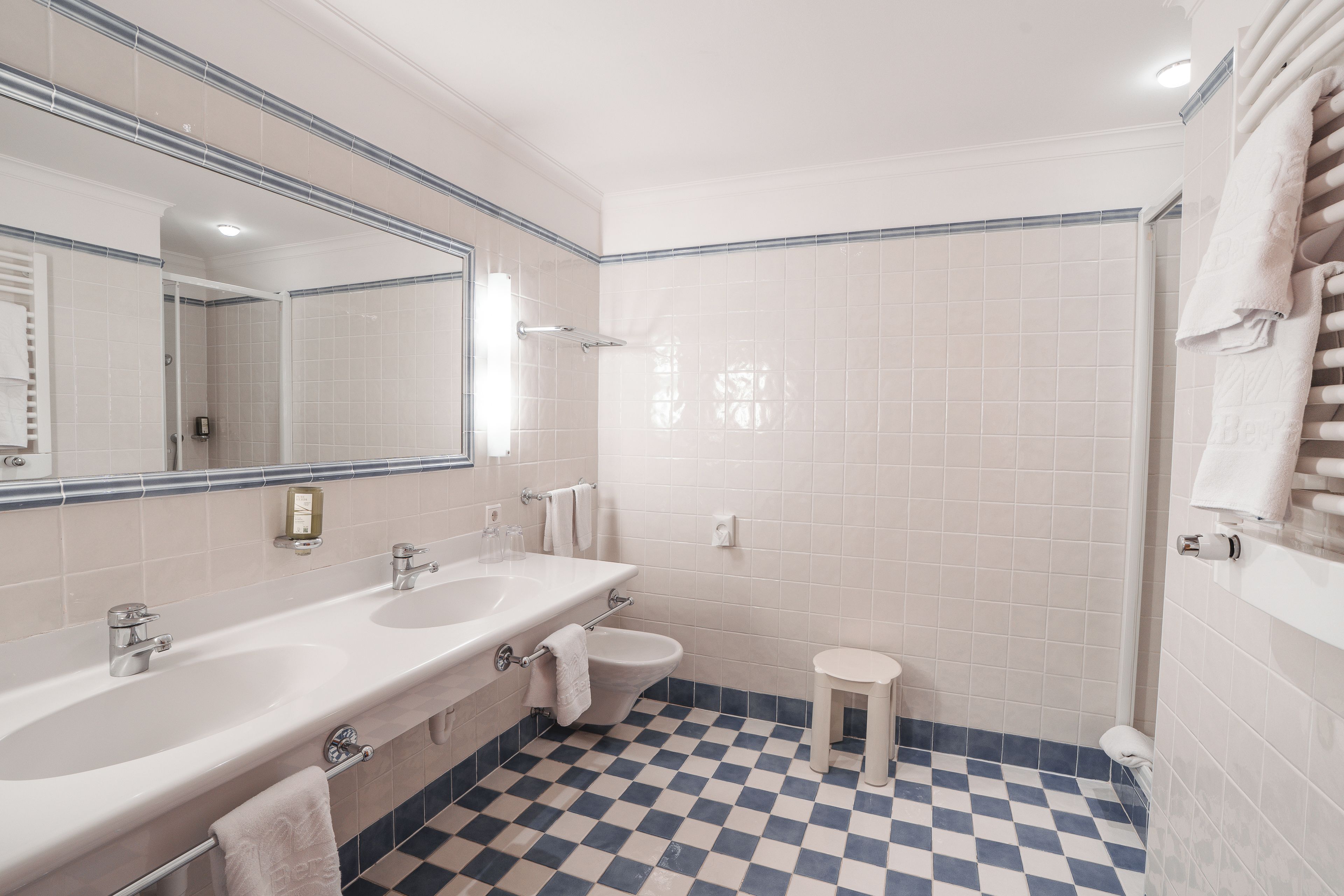 A bathroom with two sinks, a toilet, and a shower.